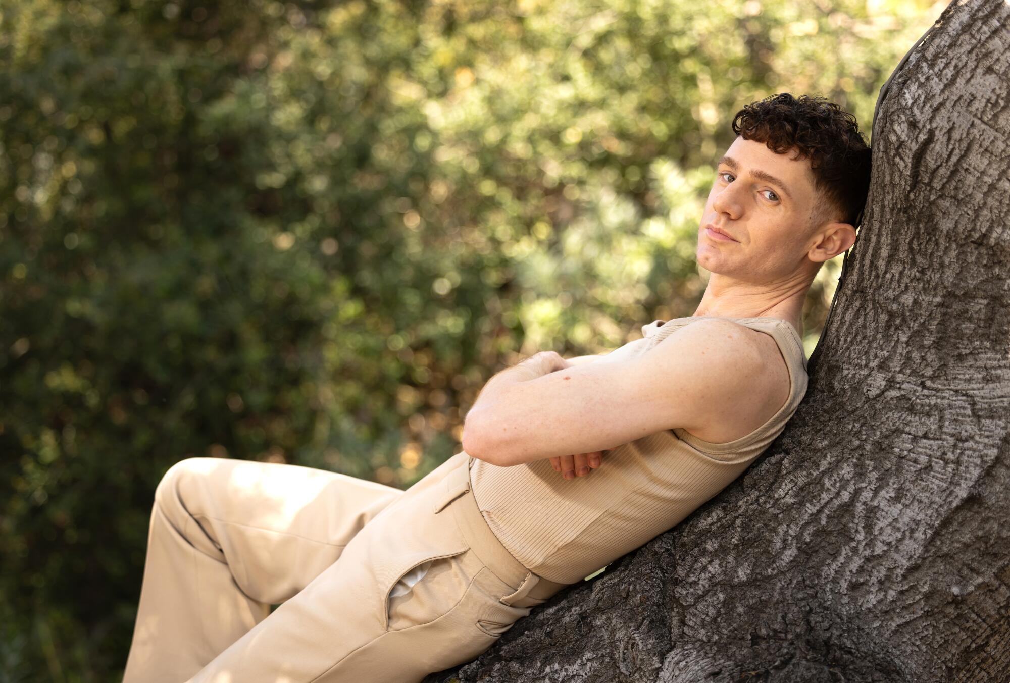 Actor Chris Perfetti leaning against a tree in the yard of his home