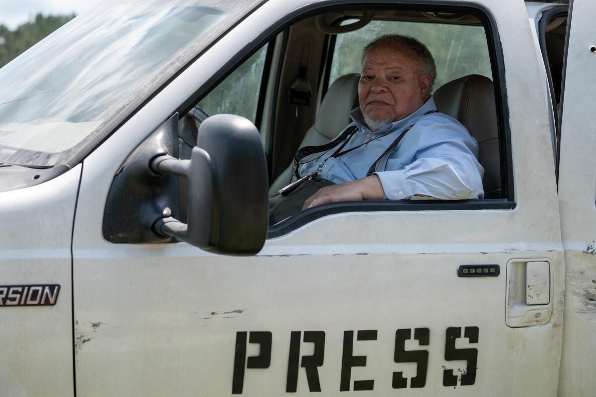 A journalist sits behind the wheel of a press truck.