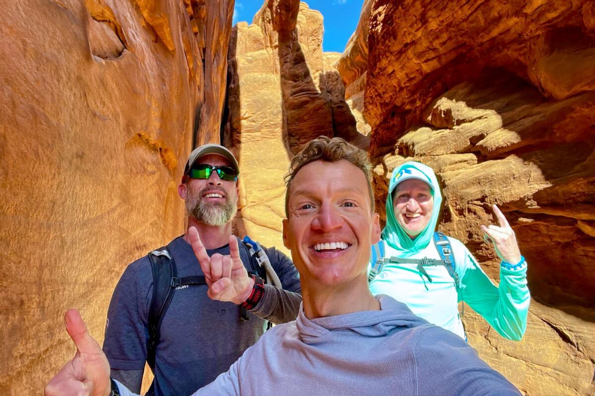 Three smiling people make hand gestures at Fiery Furnace. 