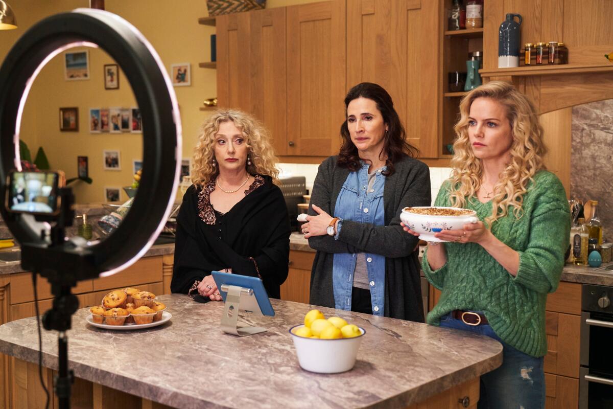 Three women prepare to demonstrate a recipe for social media in front of a ring light.