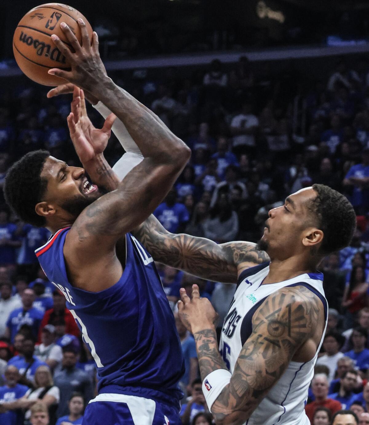 Clippers forward Paul George, left, shoots over Mavericks forward P.J. Washington.