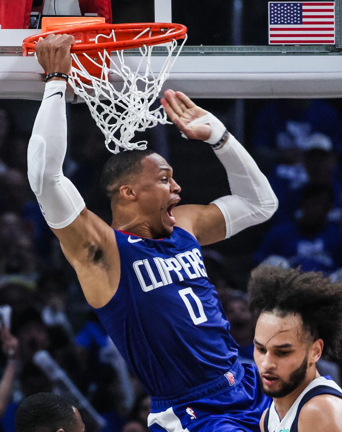 Clippers guard Russell Westbrook hangs in the air after scoring on an alley-oop dunk against the Mavericks.