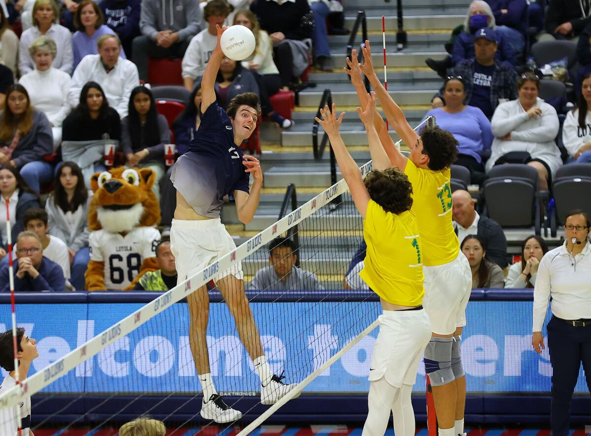 Loyola's Sean Kelly tries to spike the ball past Mira Costa's Tread Rosenthal, right, and Dominic Bell.