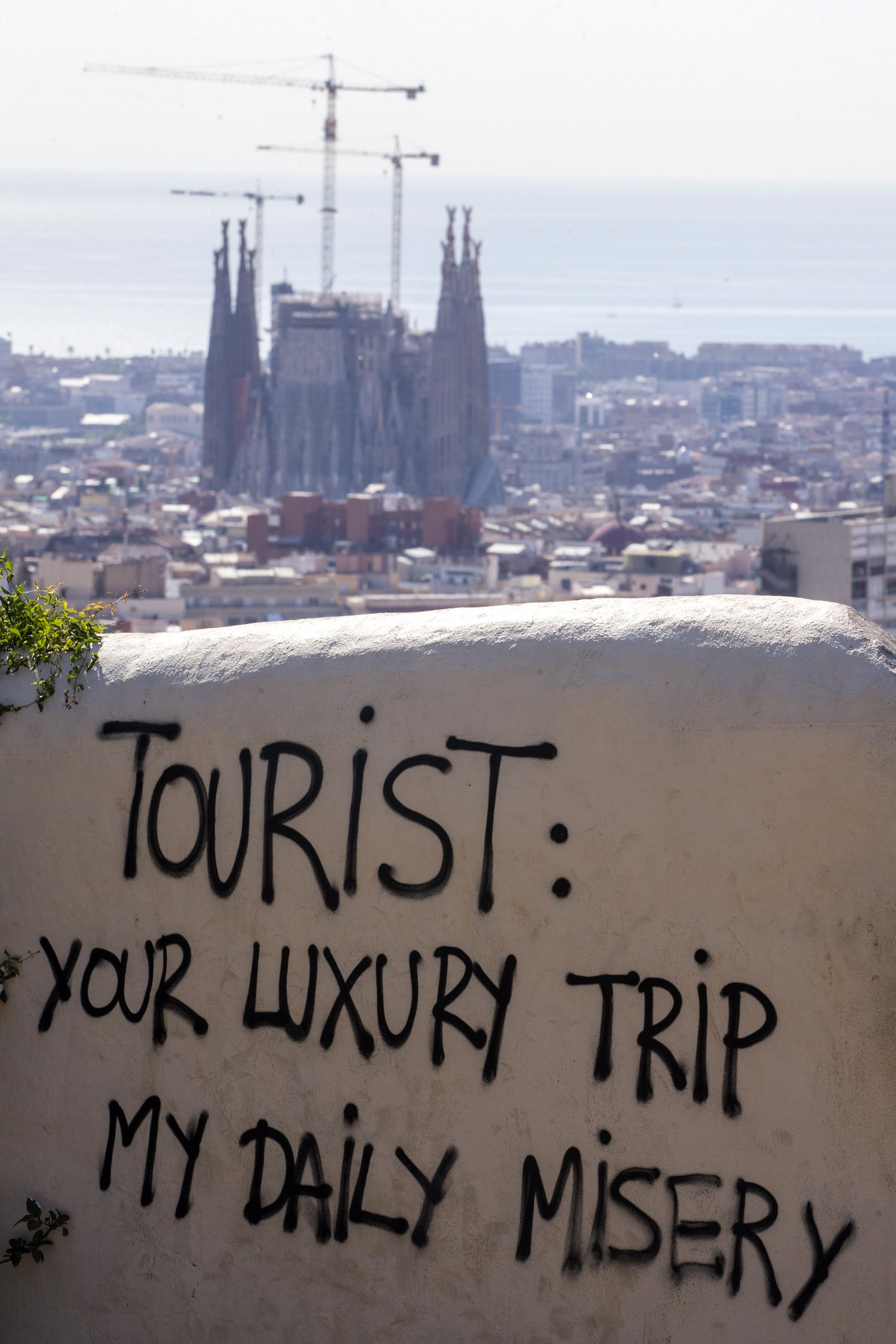 Graffiti against tourists is seen at the Guell Park in Barcelona, Spain,