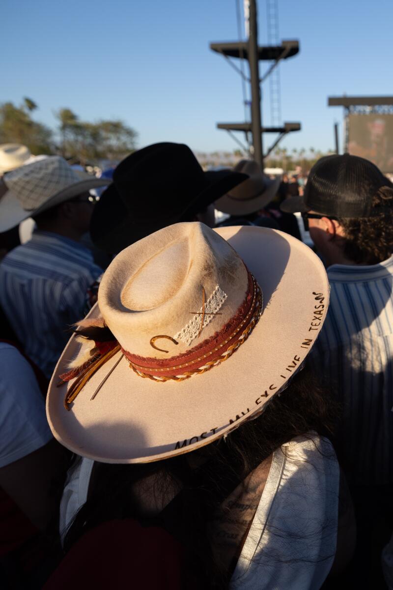 Two women sport country hats, one saying "most my Ex's Live in Texas" while watching Willie Nelson & Family.