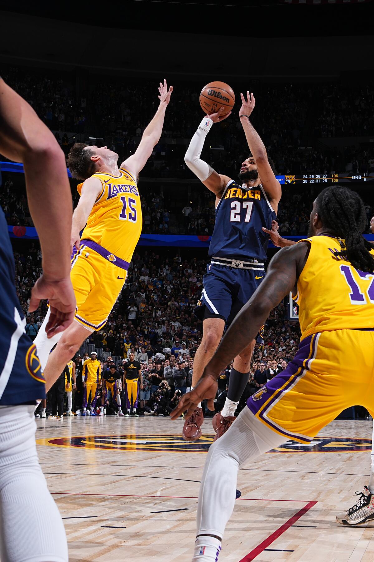 The Nuggets' Jamal Murray falls back and scores the game-winning shot over Laker Austin Reaves' extended arms 