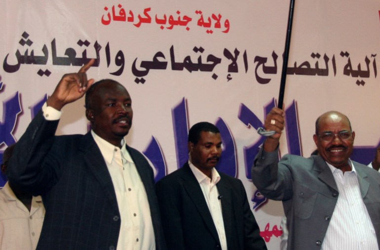 Sudan's President Omar Hassan al-Bashir waves with Governor of South Kordofan Ahmed Haroun, to participants of Civil Administrative Conference during his first visit to Kadogli