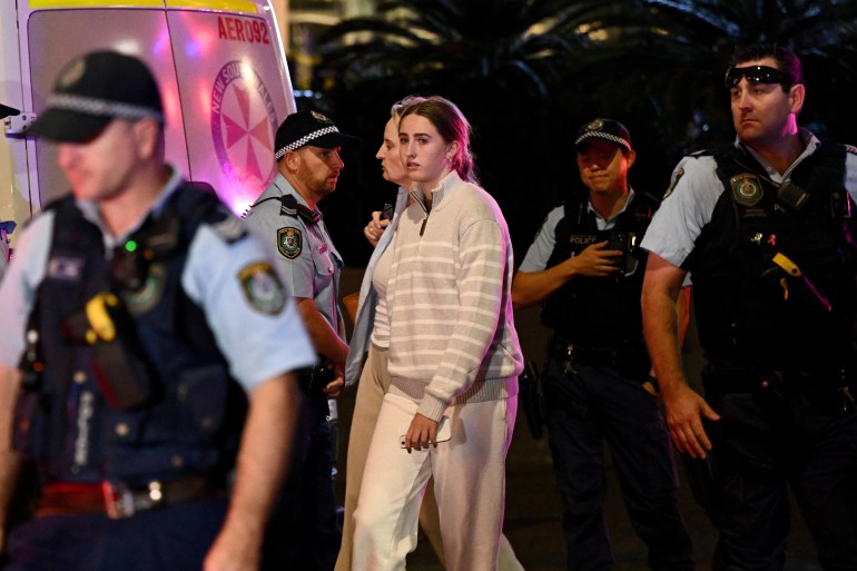 Members of the public are escorted by NSW police officers from inside Westfield Bondi Junction