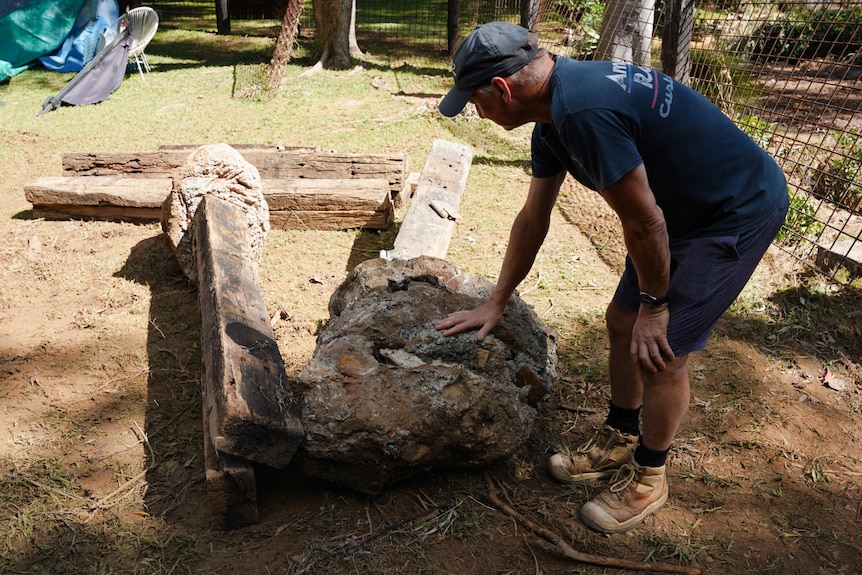 Man standing over huge concrete slabs that have been ripped from the ground.