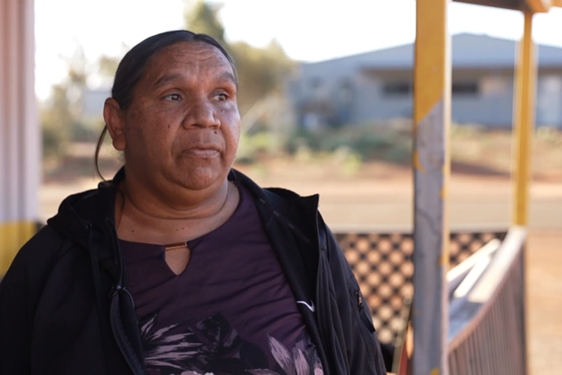 An Indigenous woman in dark clothes on an outback station.