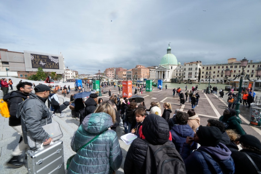 A group of tourists gather in a square.