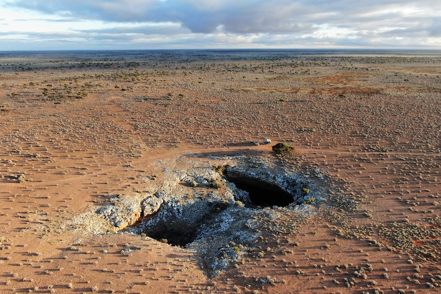 Large holes in the desert leading to underground caves. 