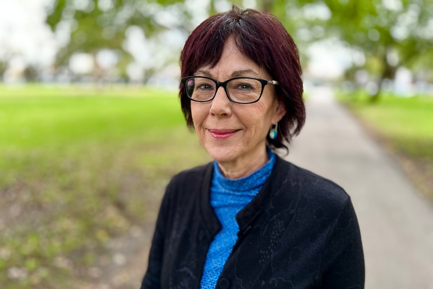 Vicki Anderson smiling with a blurry green field in the background. 