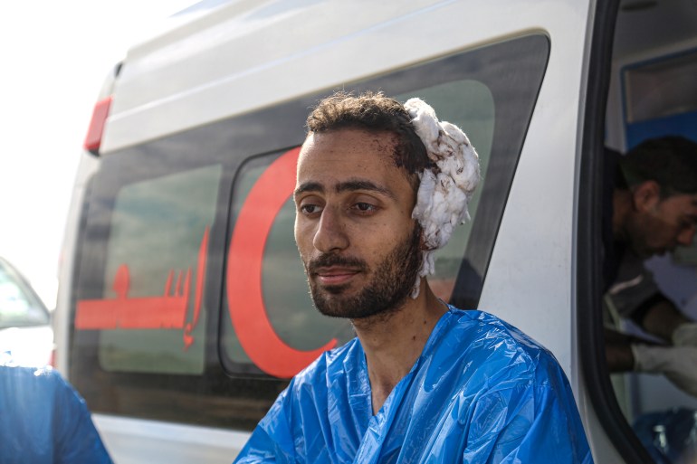 Mohamed Marshud, in a blue plastic gown to protect him from the cold, with a soiled dressing on the side of his head