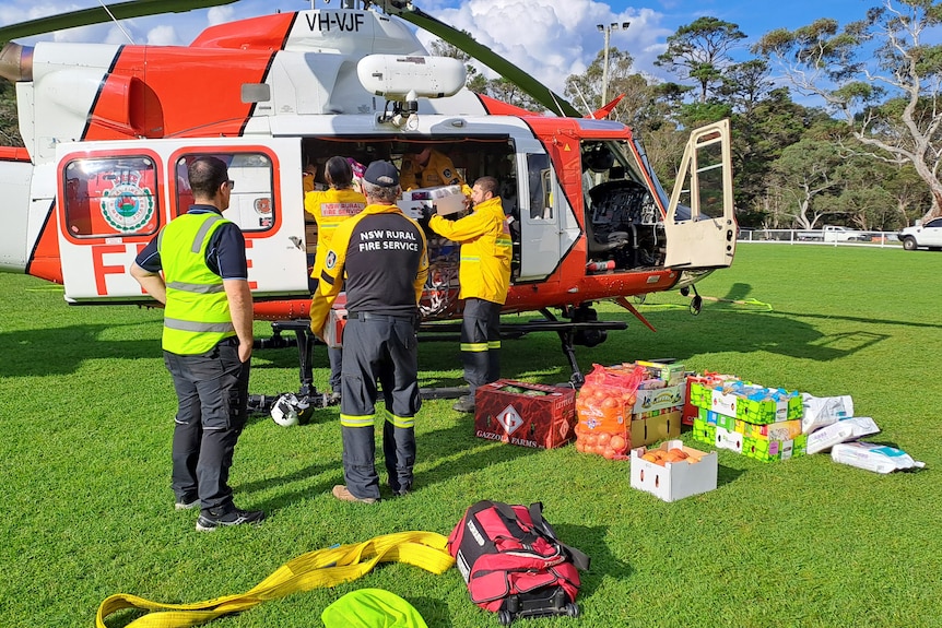 A group of people loading a helicopter with supplies