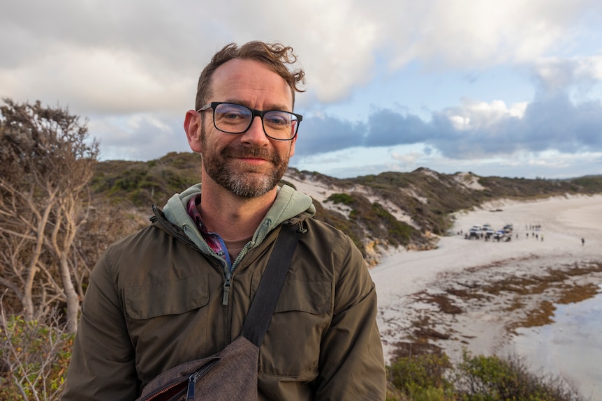 Profile of a man overlooking a beach.