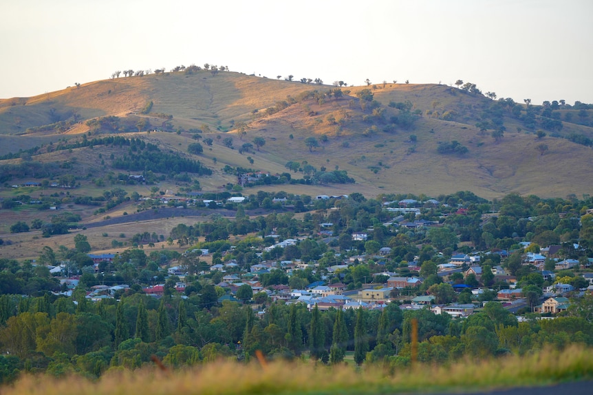 A small rural town with houses at the bottom of a valley. 