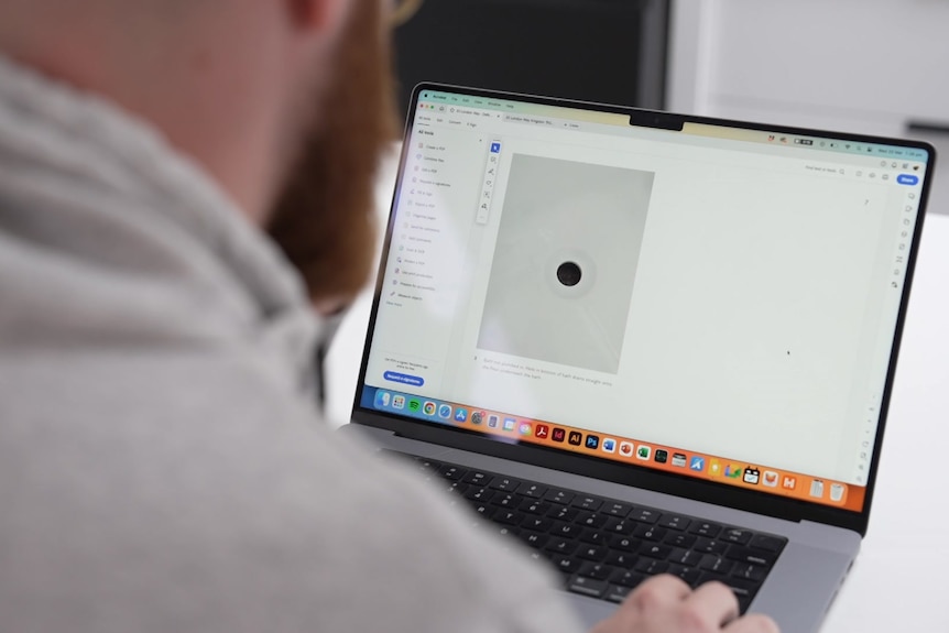 A man looks at a report on a laptop.