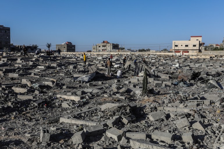 Palestinians, including children, examine the destroyed and damaged buildings and the damaged area around them collect remaining belongings from the rubble of heavily damaged buildings in the east of Rafah, Gaza on April 20