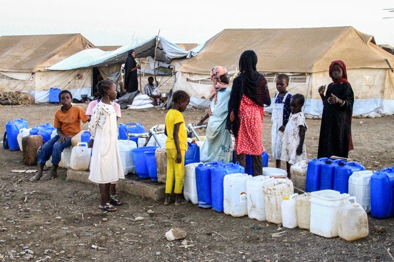 Women and children wait to fill their jerrycans with water at the Huri camp for people displaced by the ongoing conflict in Sudan, south of Gedaref in eastern Sudan, on March 29, 2024 during the Muslim holy month of Ramadan. (Photo by Ebrahim Hamid / AFP)