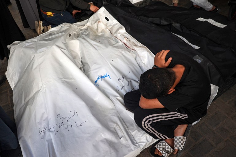 A young Palestinian mourns over the bodies of a children killed in Israeli bombing in Rafah in the southern Gaza Strip on Saturday