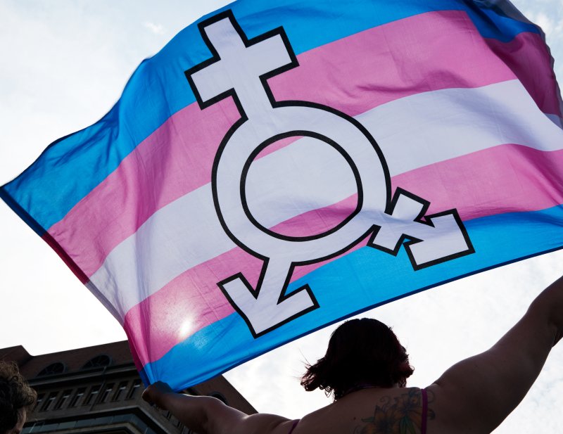 A person holds up a flag representing trans and gender-diverse people during a rally in support of human rights on the International Day against Homophobia and Transphobia in Berlin in 2018. On Tuesday, the U.S. Fourth Circuit Court of Appeals on Tuesday prevented a West Virginia ban on transgender students from participating on sports teams that match their gender identity. File Photo by Hayoung Jeon/EPA-EFE