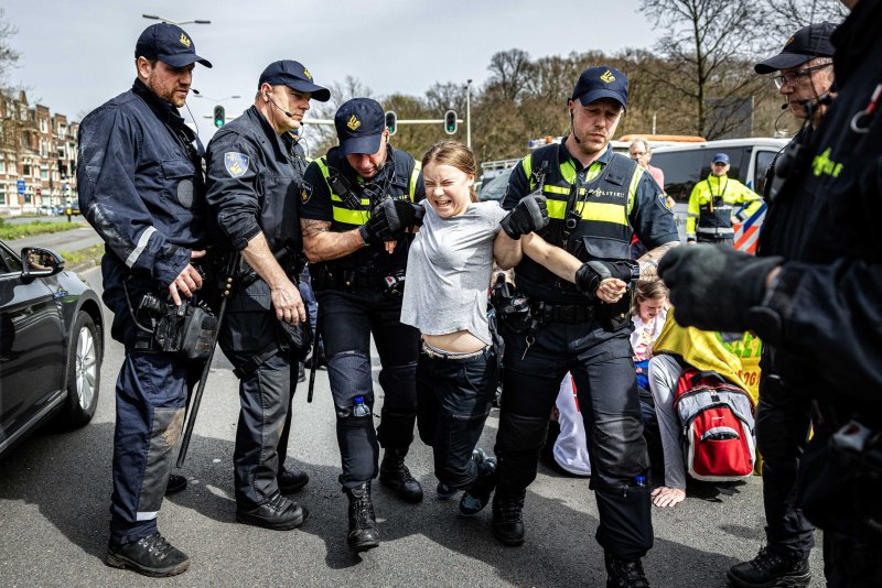 Swedish climate activist Greta Thunberg (C) is detained by police officers during a climate demonstration blocking the A12 highway in the Hague, the Netherlands, on Saturday. Thunberg joined the 37th highway blockade called by the Extinction Rebellion as new international actions against fossil subsidies were announced during the action. Photo by Ramon Van Flymen/EPA-EFE