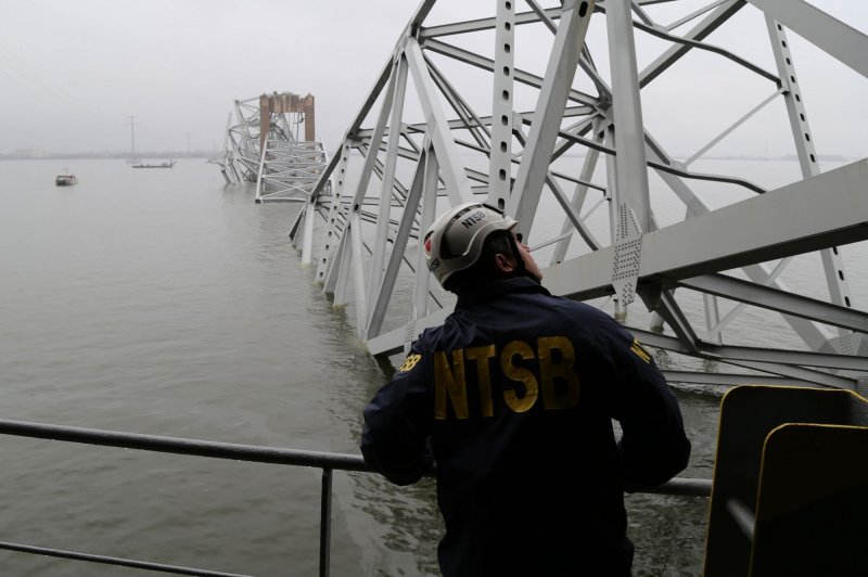 National Transportation Safety Board investigators survey the cargo vessel Dali which struck and collapsed the Francis Scott Key Bridge in Baltimore, Md. Crews on Sunday began cutting into and removing parts of the wreckage in an effort to open up a channel and get more vessels into the water. Photo by Peter Knudson/NTSB/UPI