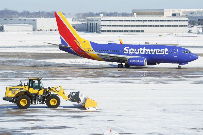 A snow sweeper attempts to pick up snow as a Southwest Airlines plane arrives at St. Louis -Lambert International Airport. A Southwest flight bound for Las Vegas Thursday halted on the runway just before liftoff and returned to its gate after the crew reported a possible engine fire. File photo by Bill Greenblatt/UPI