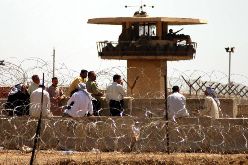 Hundreds of Iraqis gather outside of Abu Ghraib prison in Baghdad on May 4, 2004, looking for information about their relatives. On Tuesday, the trial against U.S. military contractor CACI got underway, as three former Iraqi detainees claimed they were repeatedly tortured. File Photo by Hugo Infante/UPI