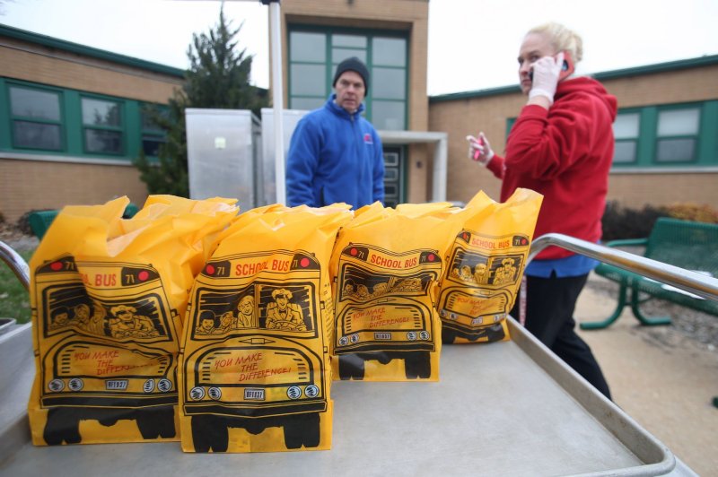 Sack lunches wait for people driving up at Fern Ridge Elementary School in Chesterfield, Mo., during the COVID-19 pandemic on March 24, 2020. New federal standards will improve the nutritious value of school meals served to students starting during the 2025-2026 school year, education officials say. File Photo by Bill Greenblatt/UPI