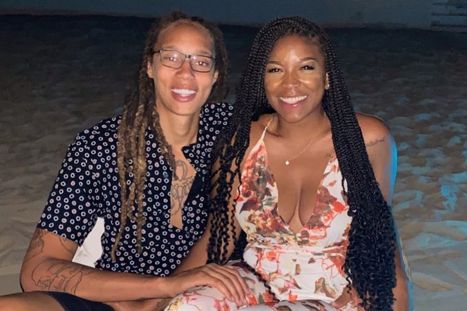 Women's basketball player Brittney Griner and her wife, Cherelle Griner, posing and smiling on the beach