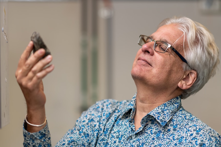 John Mavrogenes holding a rock