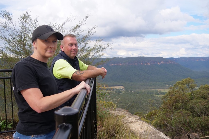 A man and woman standing next to a valley