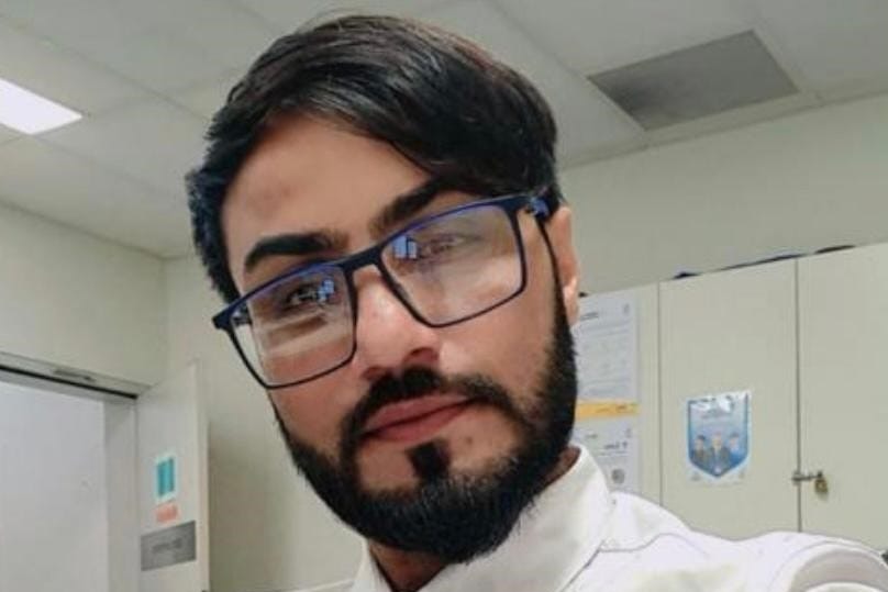 A man wearing glasses and a white collared shirt.