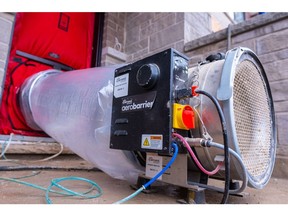 A centrifgal fan with tubing is attached to a blower door, where atomized sealant fog follows air currents through air leaks and seals them, at a home in Milton, Canada.  Photographer: Adetona Omokanye/Bloomberg