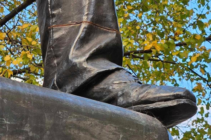 A cut halfway through the leg of a bronze statue.