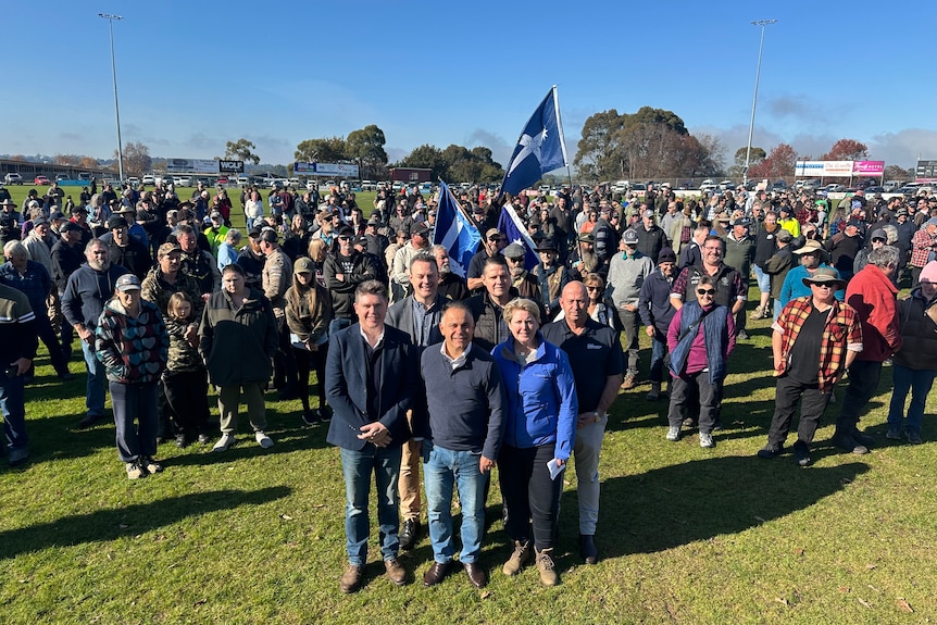 A large group of people gather at an oval. 