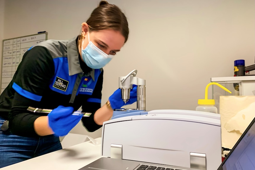 a clinic worker testing a specimen in a lab