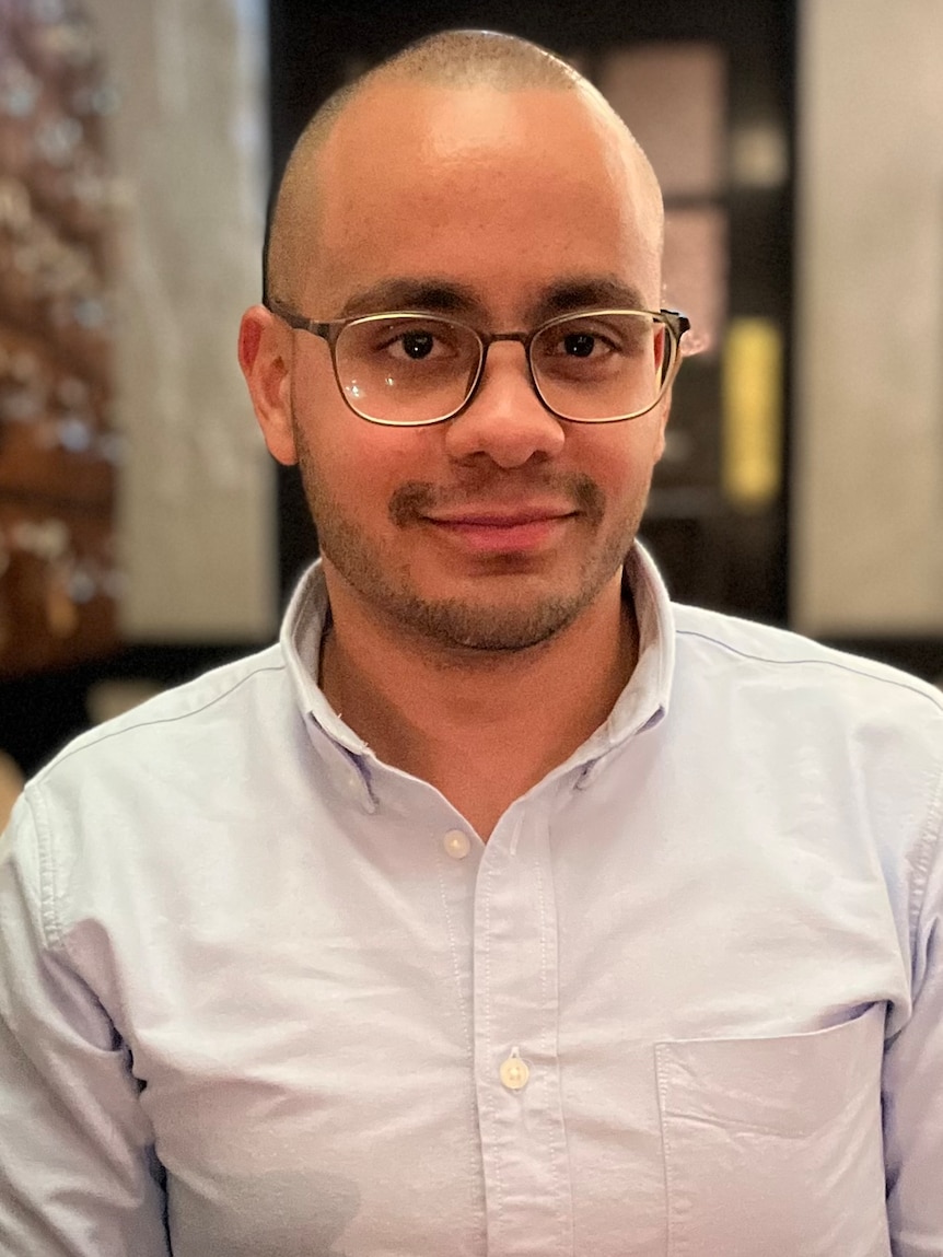 A man wearing glasses and a button-up shirt.