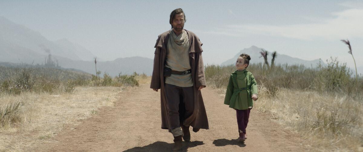 A man and girl walking on a dirt road