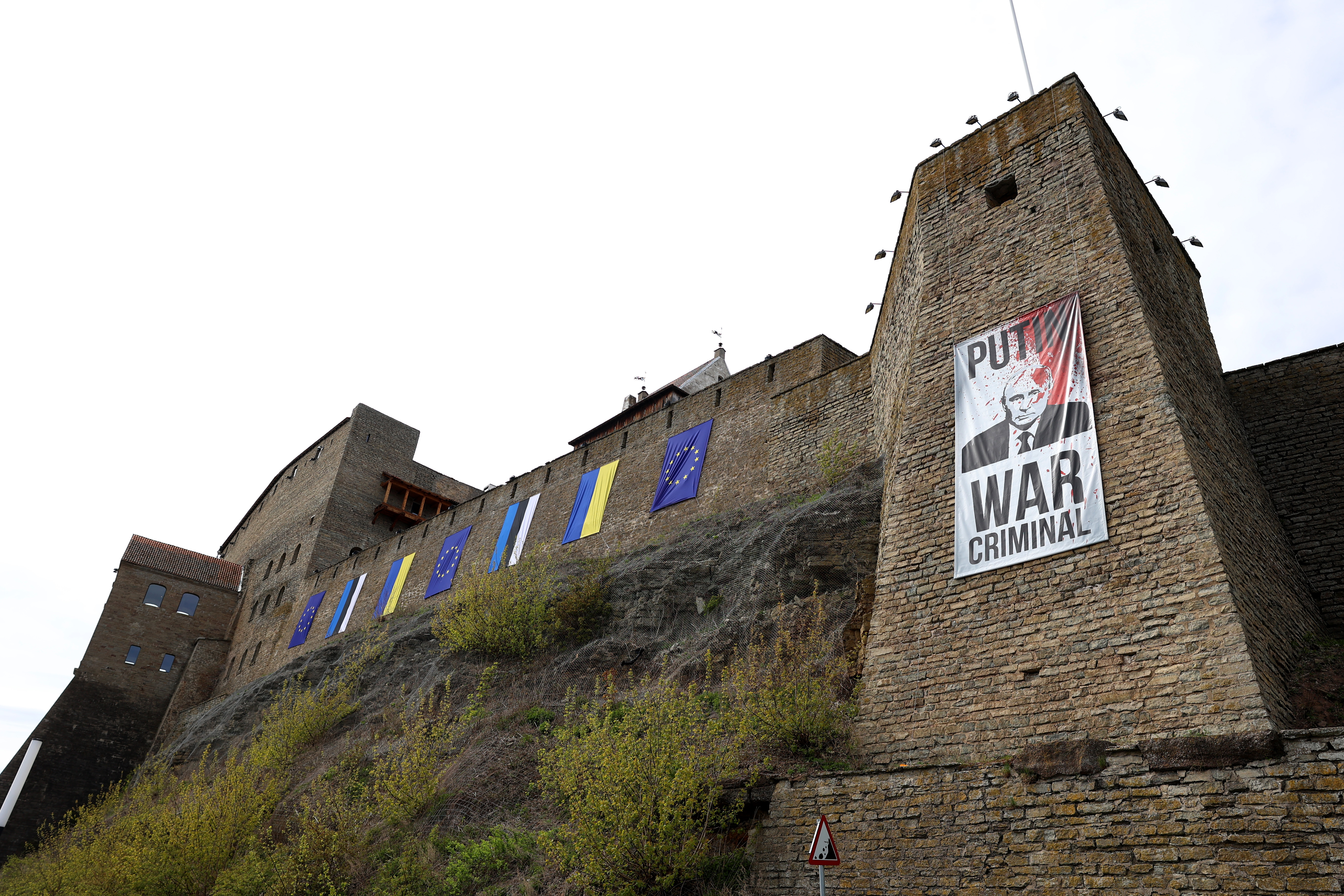 Estonian and Ukrainian flags stand side by side next to an anti-Putin poster