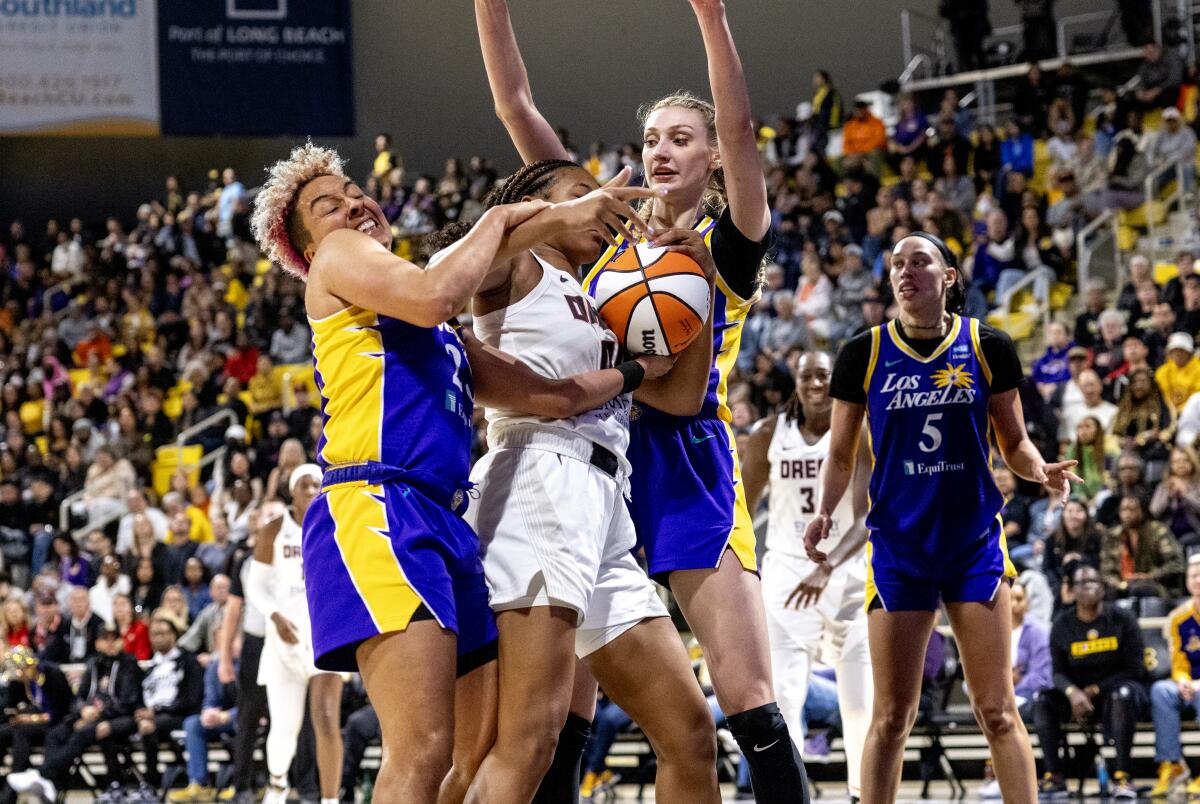 Sparks guard Layshia Clarendon ties up Dream forward Naz Hillmon for a jump ball while Cameron Brink assists 