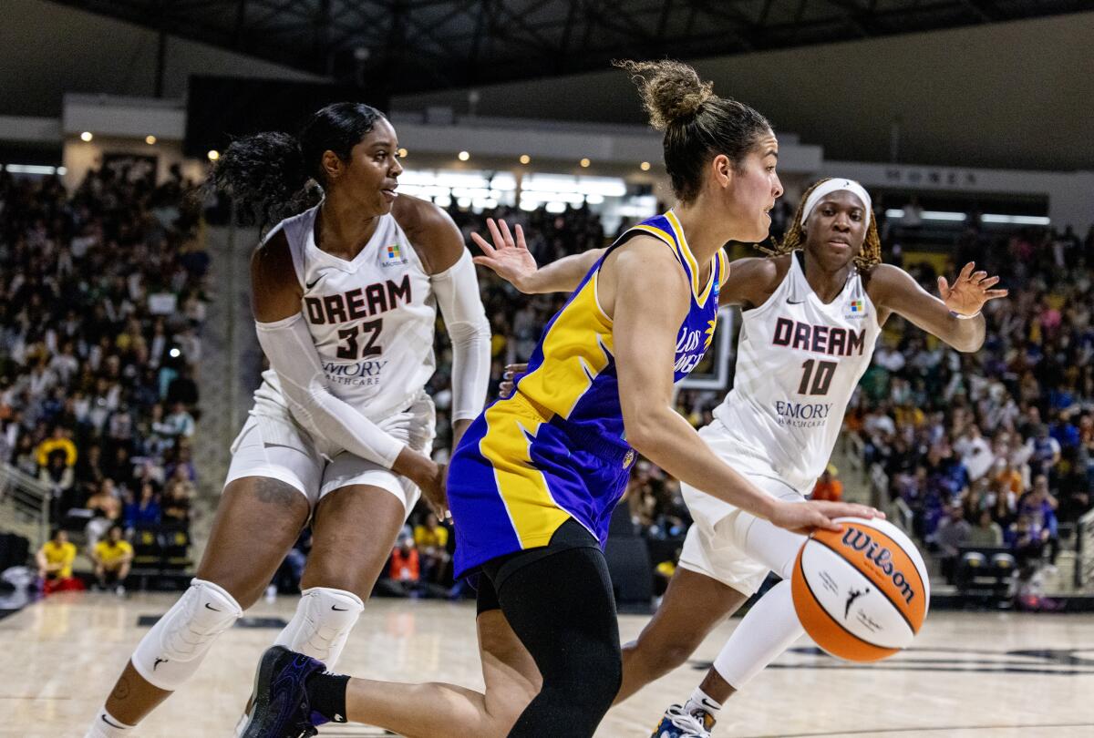 Sparks guard Kia Nurse drives along the baseline between Dream forward Cheyenne Parker-Tyus and guard Rhyne Howard