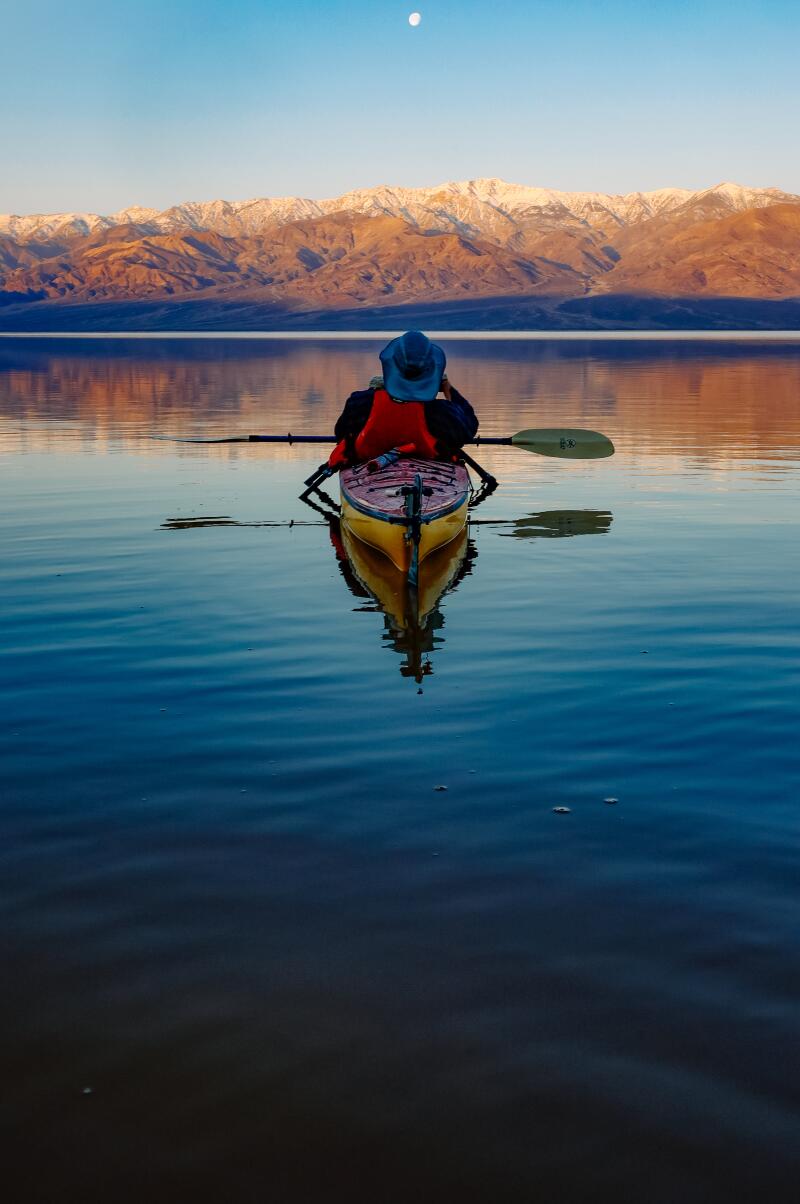 Mike "Mish" Shedlock kayaks the calm waters of Manly Lake at sunrise.