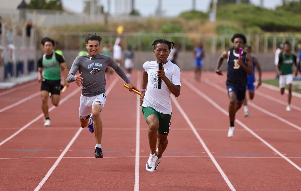 Timothy Wyatt, center, runs the last leg of Granada Hills’ winning 4x100 relay. 