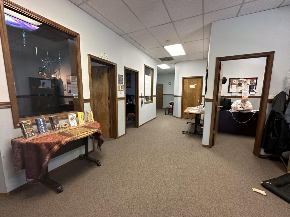 A large clean office interior with glass windows and brown carpeting   