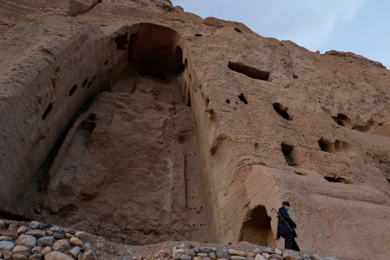 A Taliban soldier stands guard in front of ruins in the central Bamyan province of Afghanistan