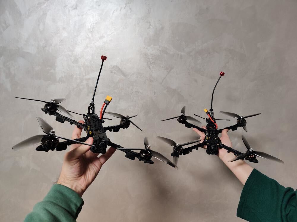 Zhanna and Dmytro proudly hold up the FPV drones they built with their own hands