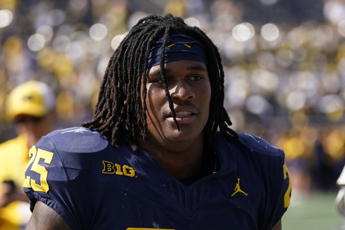 Michigan linebacker Junior Colson (25) leaves the field after a game against Rutgers .